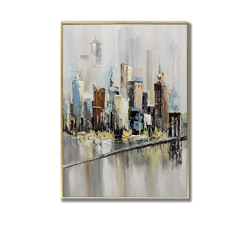 May include: Abstract painting of a cityscape with a bridge in the foreground. The buildings are painted in shades of brown, blue, and white, and the water is a light gray. The painting has a gold frame.