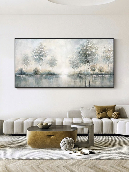 May include: A framed landscape painting depicts a serene waterscape with trees. The artwork features a muted color palette of blues, greens, and whites, creating a tranquil and atmospheric scene. The painting is rectangular and mounted in a black frame.
