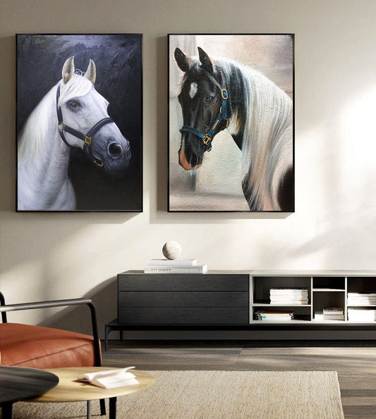 May include: Two framed paintings of horses. The painting on the left features a white horse with a black background. The painting on the right features a black and white horse with a light background.