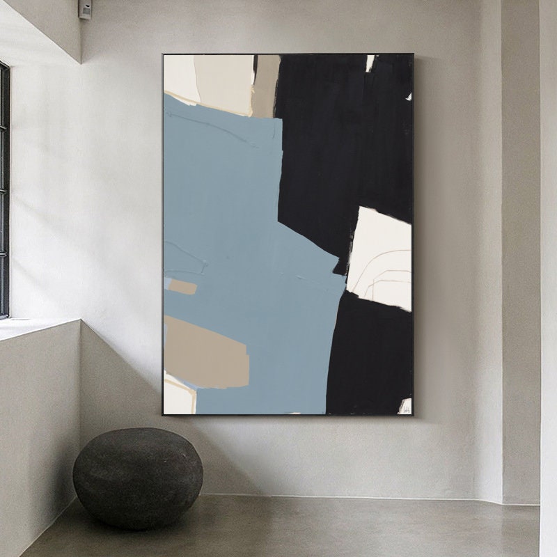 May include: Abstract art print with black, blue, and beige paint strokes on a white background. The print is framed in a black frame.
