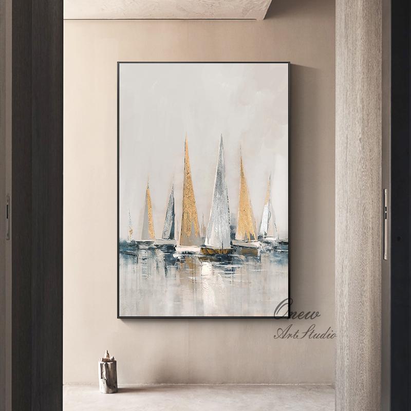 May include: Abstract painting of sailboats on a light blue and white background with gold accents. The painting is framed in a black frame.