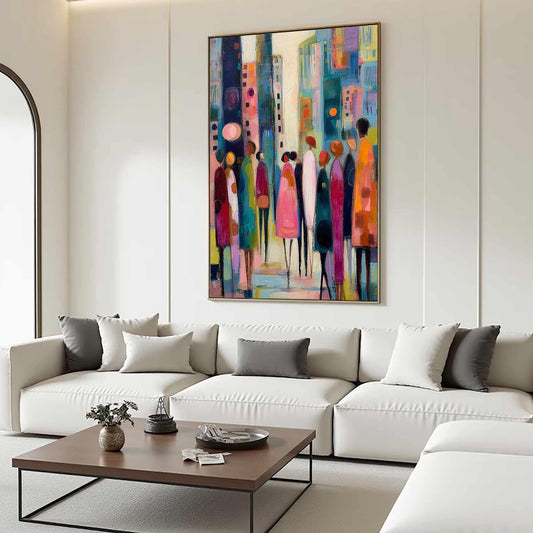 May include: Abstract cityscape painting with a gold frame. The artwork features a colorful depiction of a city street with stylized figures in various colors, including pink, orange, and blue. The painting hangs above a white sectional sofa.