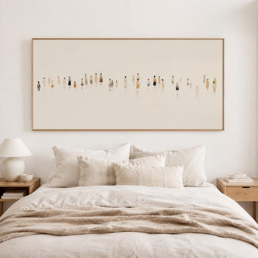 May include: A large rectangular framed artwork depicting a minimalist scene of numerous figures in various colors. The artwork hangs above a bed with cream-colored bedding and pillows, creating a serene bedroom setting.