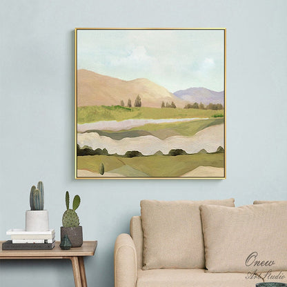 May include: Abstract landscape painting with a gold frame. The painting features a green and brown landscape with hills, trees, and a river. The sky is a light blue with white clouds.