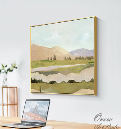 May include: Abstract landscape painting with a gold frame. The painting features a green field with rolling hills in the background. The sky is a light blue with a few white clouds.