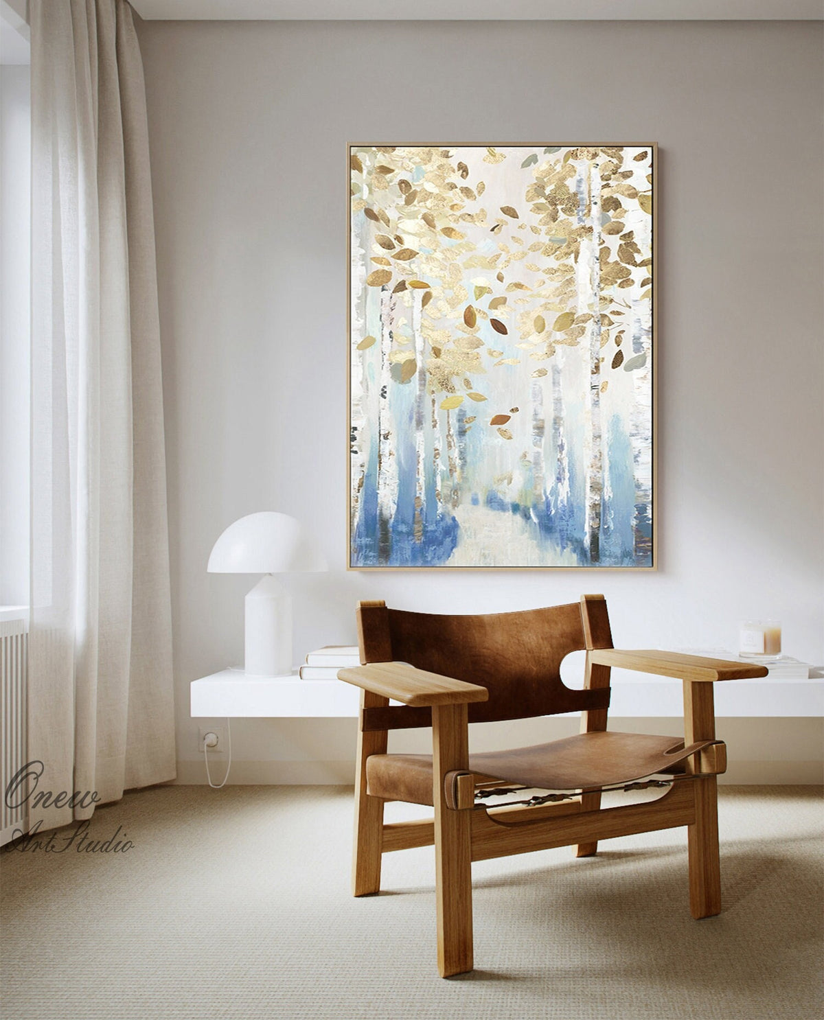 May include: An abstract painting of a birch forest with gold and brown leaves. The artwork features white birch tree trunks with blue and gold accents. The painting is framed in a gold-colored frame and hangs on a light gray wall.