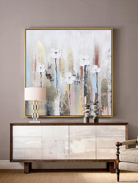 May include: A large abstract painting with a white background and gold accents. The painting features white flowers with brown stems and is framed in a gold frame.