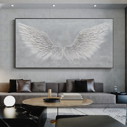 May include: A large abstract painting of white angel wings on a gray background. The wings are textured and appear to be made of feathers. The painting is framed in a black frame.