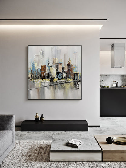 May include: Abstract painting of a cityscape with a bridge in the foreground. The painting is done in shades of gray, blue, brown, and yellow. The painting is framed in a black frame and is hanging on a white wall.