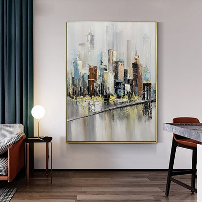 May include: Abstract painting of a cityscape with a bridge and water reflection. The painting is done in shades of gray, brown, blue, and yellow. The painting is framed in gold.