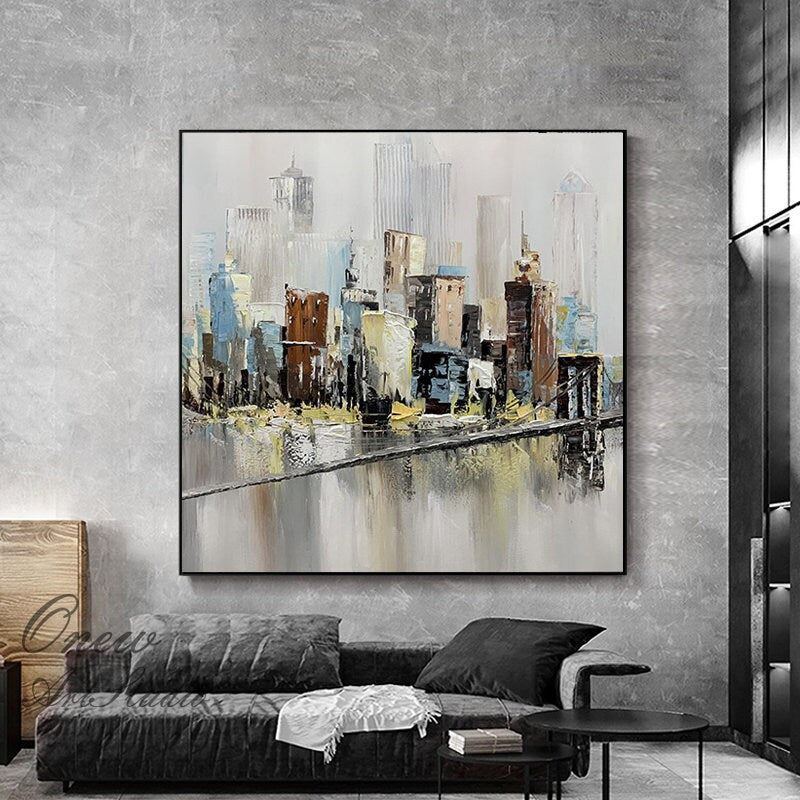May include: Abstract painting of a cityscape with a bridge over a river. The painting is done in shades of blue, brown, and gray. The buildings are tall and slender, and the bridge is a simple, straight line.