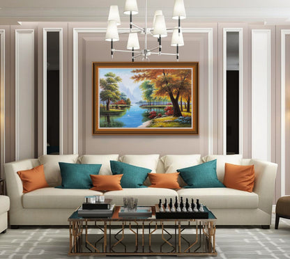 May include: A framed painting of a forest scene with a river running through it. The trees are in autumn colors, with red, orange, and yellow leaves. The river is blue and there are white birds flying over it. The painting is hanging on a wall in a living room with a white sofa and orange and teal pillows.