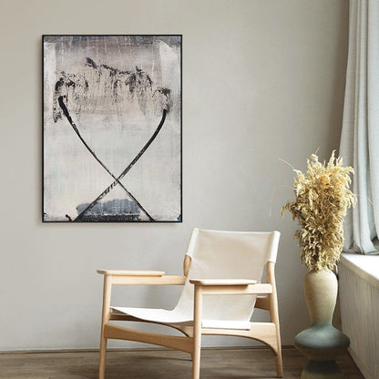 May include: A black and white abstract painting with a light gray background. The painting features two thick black lines that cross in the center of the canvas. The lines are slightly curved and create a sense of movement. The painting is framed in a black frame and is hanging on a white wall.