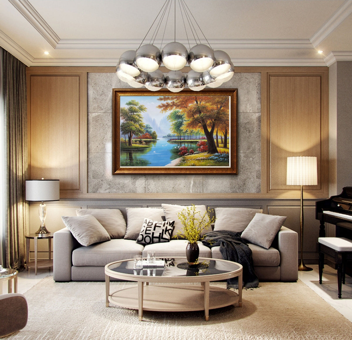May include: A living room interior with a gray sofa, a round coffee table, and a framed landscape painting of a forest scene with a lake. The painting is in a gold frame and features a variety of trees in shades of green, yellow, and red. The room is decorated with a modern chandelier and a floor lamp.