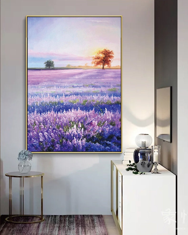 May include: A painting of a lavender field with a single orange tree in the distance. The sky is a soft pink and blue, and the sun is setting behind the tree.