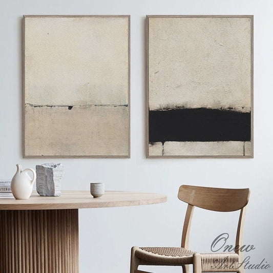 May include: Two abstract paintings with a minimalist design. The painting on the left is mostly beige with a thin black line across the middle. The painting on the right is mostly beige with a thick black line across the middle.