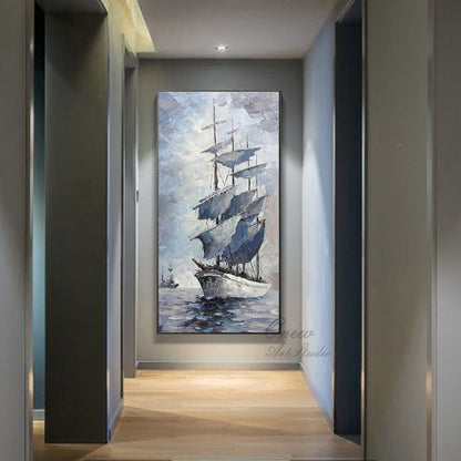 May include: A painting of a tall ship with white sails against a blue and gray sky. The ship is sailing on a calm sea. The painting is framed and hanging on a wall in a hallway.