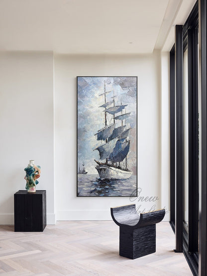May include: A framed painting of a sailboat with white sails against a blue and gray sky. The sailboat is in the water with a few other boats in the distance. The painting is hanging on a white wall in a modern home.