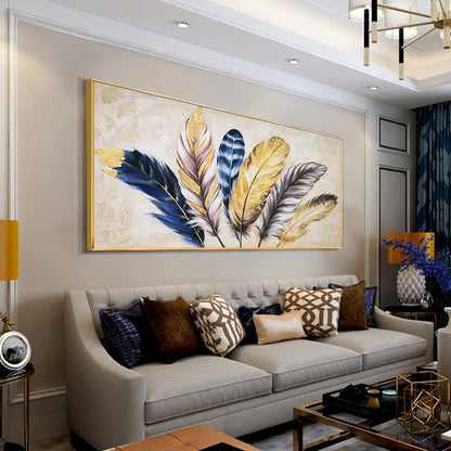 May include: A framed canvas painting featuring a cluster of stylized feathers in shades of gold, blue, and gray. The feathers are arranged in a fan-like pattern against a cream background.