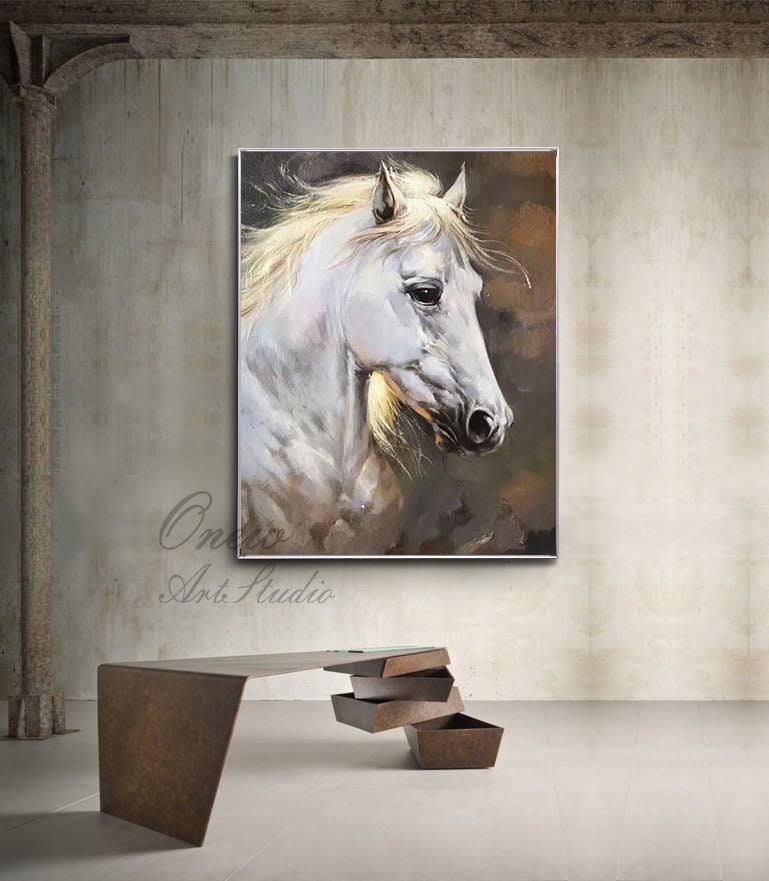 May include: A painting of a white horse with a flowing mane, set against a brown background. The horse's head is turned to the side, and its eyes are closed. The painting is framed in a simple silver frame.