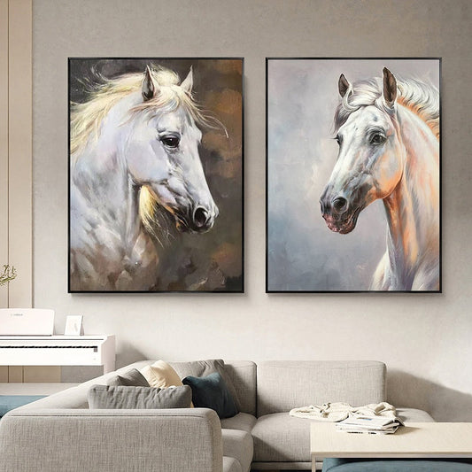 May include: Two framed paintings of white horses with brown and grey backgrounds. The horses are facing different directions.