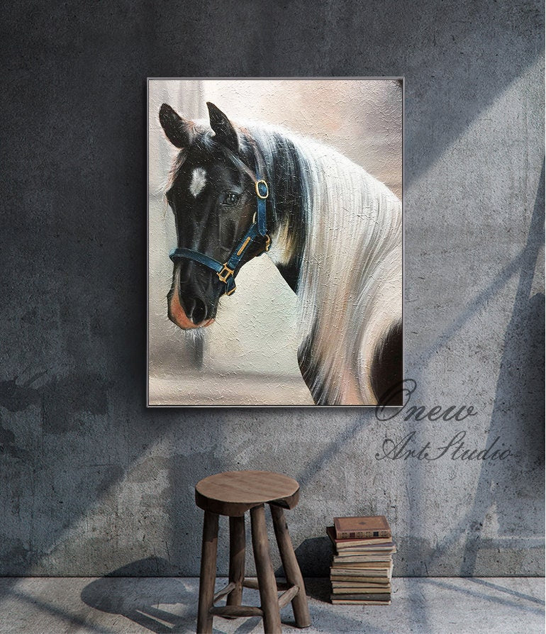 May include: A painting of a black and white horse with a blue halter. The horse is looking to the left and has a white star on its forehead. The background is a light beige color.