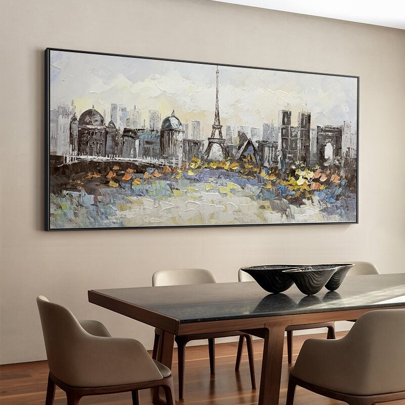 May include: A framed painting depicting a cityscape with the Eiffel Tower in the center. The painting is done in a painterly style with a mix of gray, white, and brown colors.