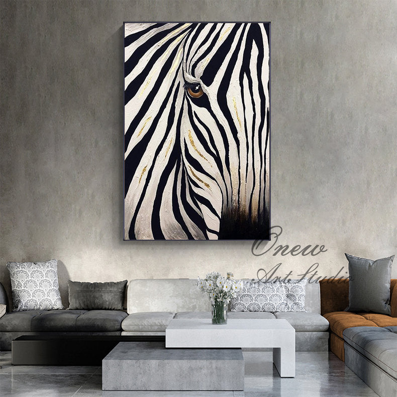 May include: A framed canvas art piece featuring a close-up of a zebra's face. The artwork showcases black and white stripes with gold accents, and a brown eye. The painting is displayed on a gray wall above a modern living room.