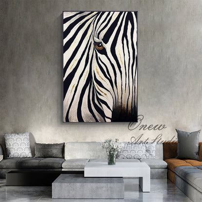 May include: A framed canvas art piece featuring a close-up of a zebra's face. The artwork showcases black and white stripes with gold accents, and a brown eye. The painting is displayed on a gray wall above a modern living room.