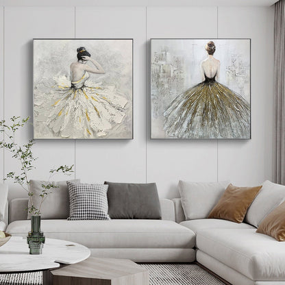 May include: Two square canvas paintings of a ballerina in a white and gold dress. The ballerina is facing away from the viewer in both paintings. The paintings are hung on a white wall above a white couch.