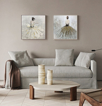 May include: Two framed paintings of women in flowing dresses. The paintings are in a living room setting with a couch, coffee table, and decorative vases.