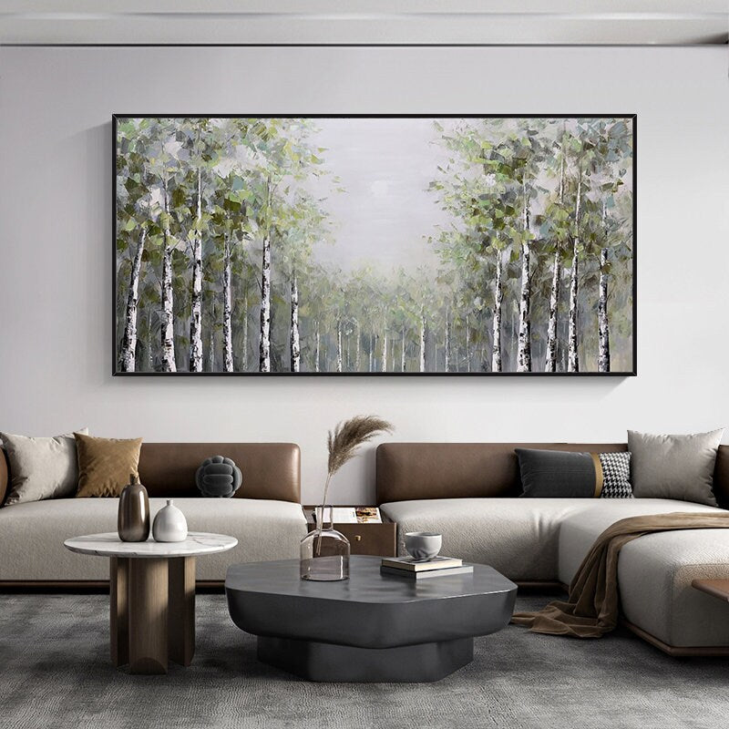 May include: A painting of a forest with tall, slender trees with white bark. The trees are painted in a muted green and white color palette, with a soft, hazy background. The painting is framed in a black frame and hangs on a white wall.