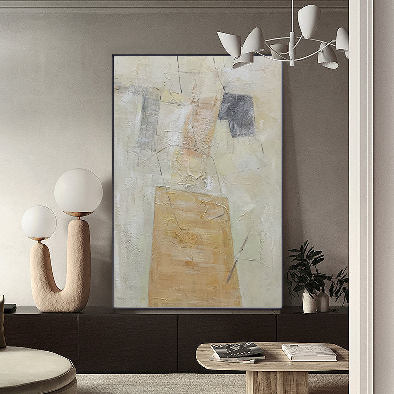 May include: Abstract painting with a textured, layered look. The painting features shades of beige, brown, and gray, with a prominent rectangular shape in the center. The painting is framed in a black frame and is hanging on a wall in a modern interior.