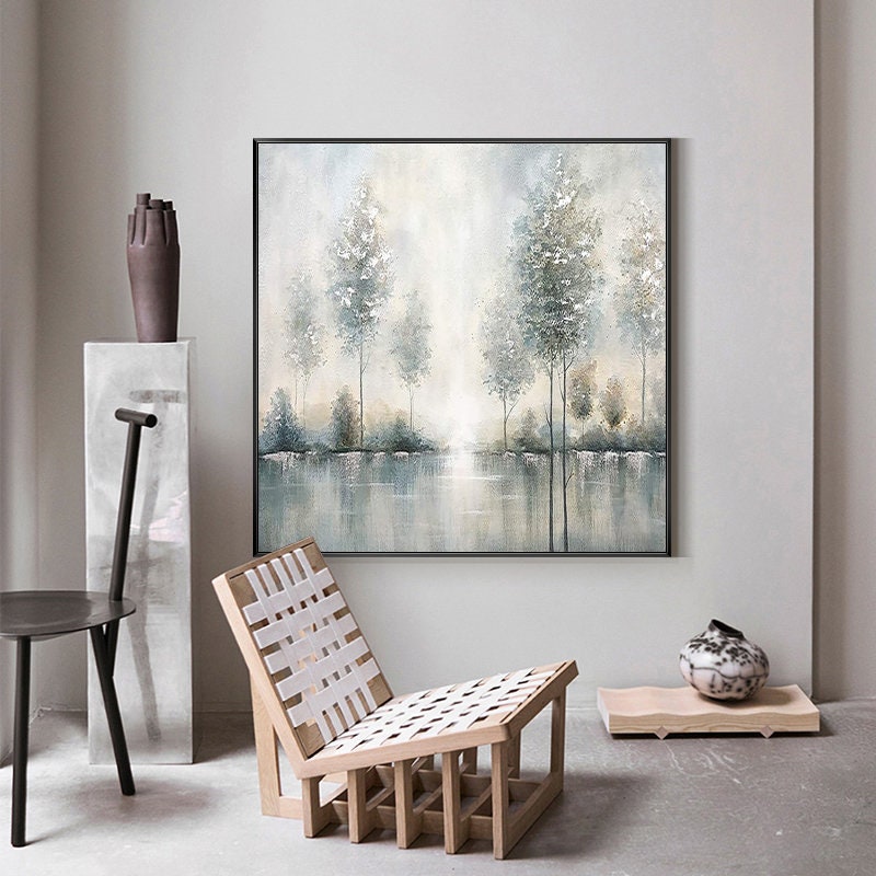 May include: A framed painting of a misty forest scene with trees reflected in a still body of water. The painting is in shades of gray, blue, and white.