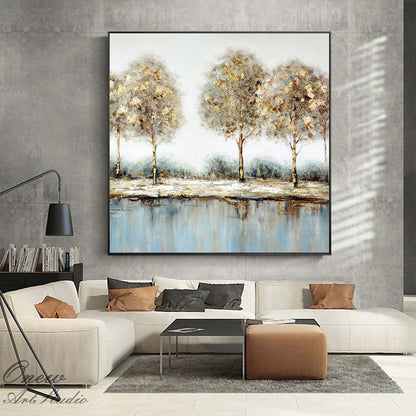 May include: Abstract painting of three trees with gold and brown leaves reflected in a blue lake. The painting has a textured, brushstroke effect.