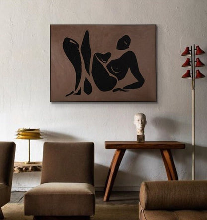 May include: A black and white abstract painting of a person reclining on a brown background. The painting is framed and hanging on a wall.