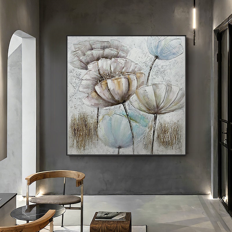 May include: A square canvas painting featuring a floral design with large, white, and light blue flowers with brown stems on a white background.