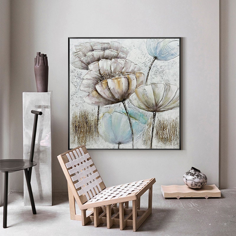 May include: A framed canvas painting featuring a floral design with white, brown, and blue flowers on a textured white background.