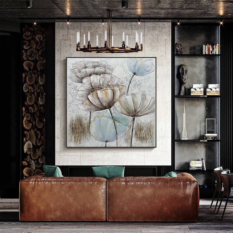 May include: A square canvas painting with a floral design. The painting features large, white flowers with brown centers and light blue accents. The background is a light gray with a textured look.