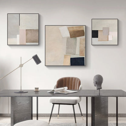 May include: Three abstract art prints with geometric shapes in shades of brown, beige, white, and black. The prints are framed in black and hung on a white wall.