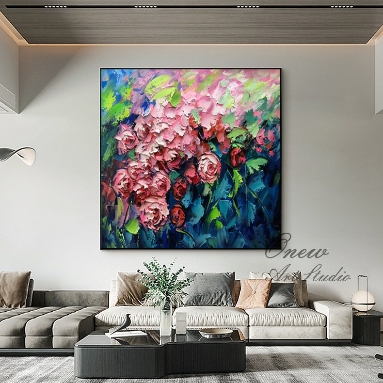 May include: A vibrant abstract painting featuring a cluster of pink roses with green leaves against a blue background. The painting has a textured, impasto style.