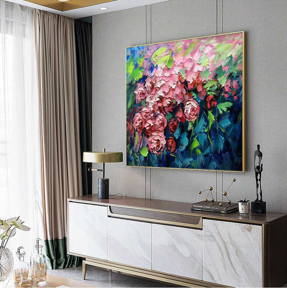 May include: A painting of a bouquet of pink roses with green leaves against a blue background. The painting is framed in gold and hanging on a gray wall.