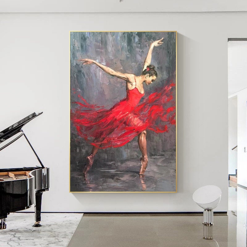 May include: A painting of a ballerina wearing a red dress and pointe shoes. The ballerina is in mid-air, with her arms outstretched and her legs extended. The background is a dark gray color, and the painting is done in a realistic style.