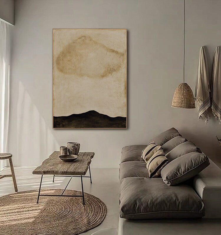 May include: Abstract painting with a beige background and a large, light brown cloud shape. The bottom of the painting is a dark brown, almost black, horizontal line.