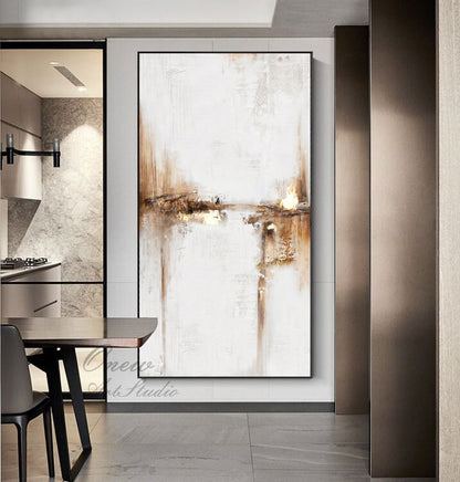 May include: Abstract painting with brown and white brushstrokes on a white canvas. The painting is hanging on a wall in a modern home.