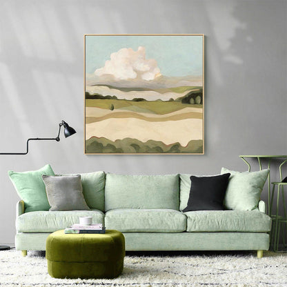 May include: A green sofa with two pillows, one gray and one black, sits in front of a painting of a landscape with a large white cloud. A green ottoman sits in front of the sofa.