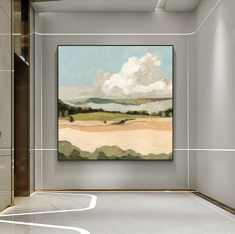 May include: Abstract landscape painting with a large white cloud in a blue sky over a green and brown field. The painting is framed in black and hanging on a gray wall.