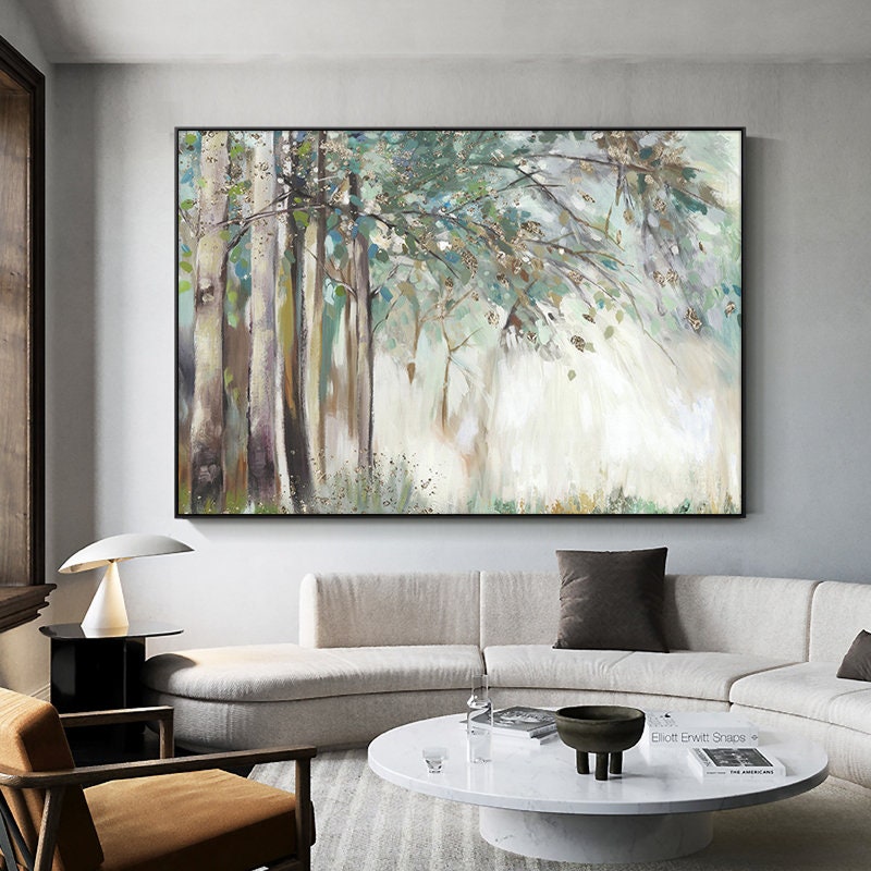 May include: A painting of a forest scene with tall trees and green leaves. The background is a soft white with hints of gold. The painting is framed in a black frame.