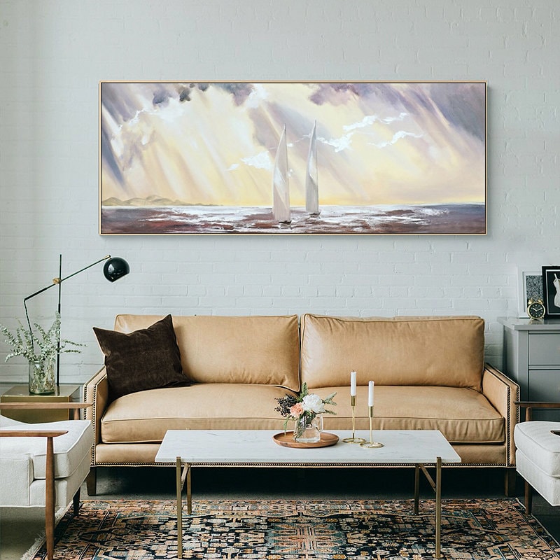 May include: A painting of two white sailboats on a body of water with a yellow and purple sky. The sky is filled with clouds and rays of light.