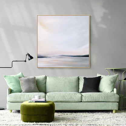 May include: A light green sofa with three pillows, a green ottoman, and a framed abstract painting of a seascape in muted tones of gray, white, and pink.